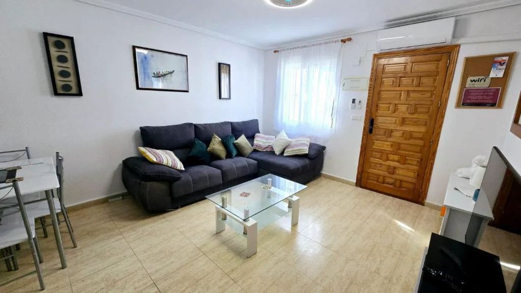 Salón con sofás negros y mesa de centro