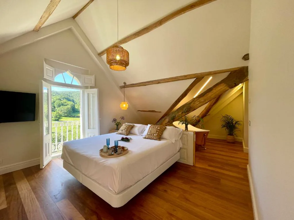 Buhardilla con cama y balcón con vistas al valle, bandeja de desayuno sobre la cama, Villa Boutique 1880