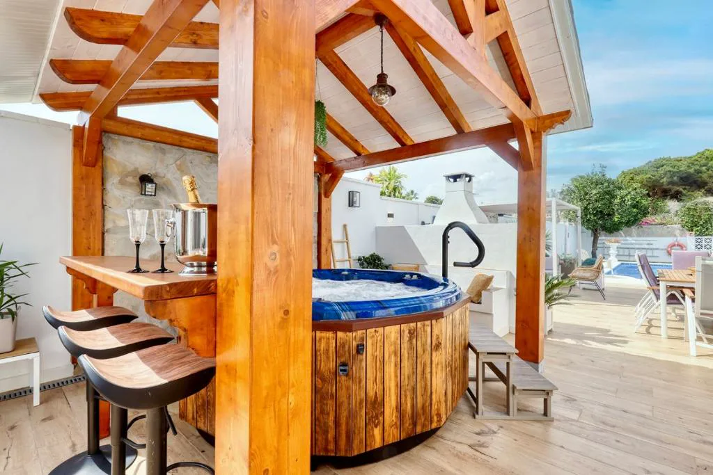 Jacuzzi y barra bajo una pérgola de madera