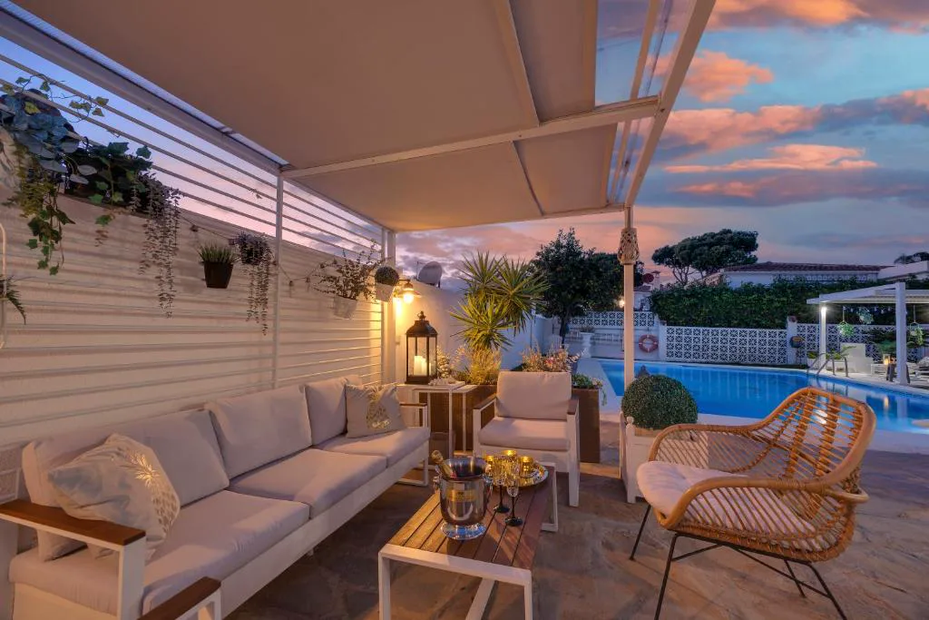 Salón exterior al atardecer junto a la piscina