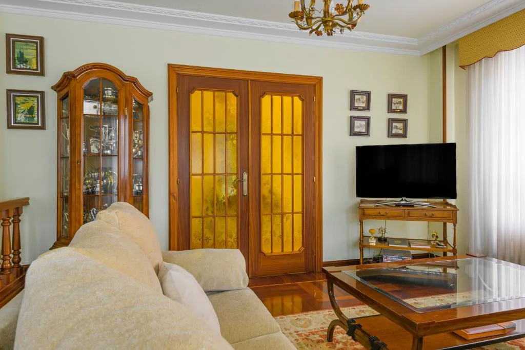 Salón con sofá, vitrina y televisión