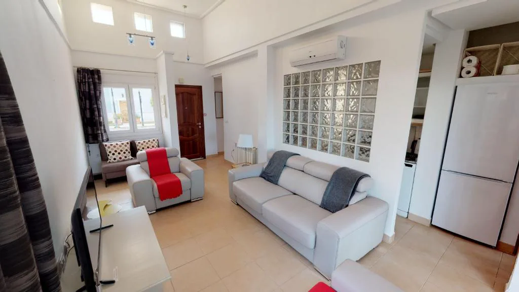 Salón con sofás y cocina abierta