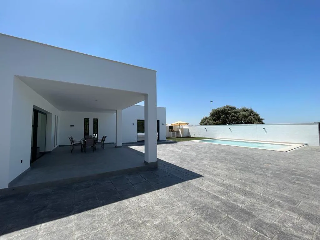 Fachada de la casa con amplio patio pavimentado