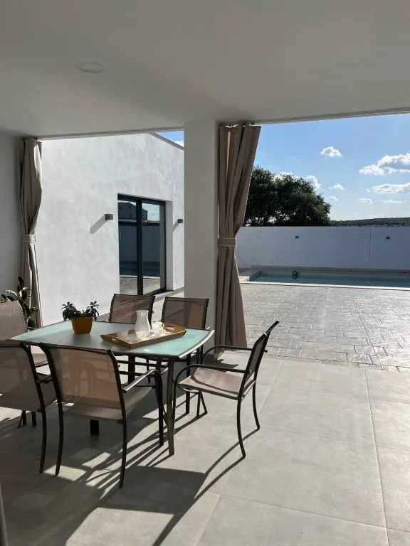 Terraza cubierta con mesa y sillas