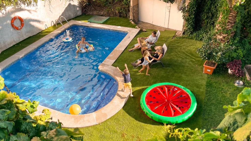 Piscina con forma libre y un flotador de sandía en un jardín