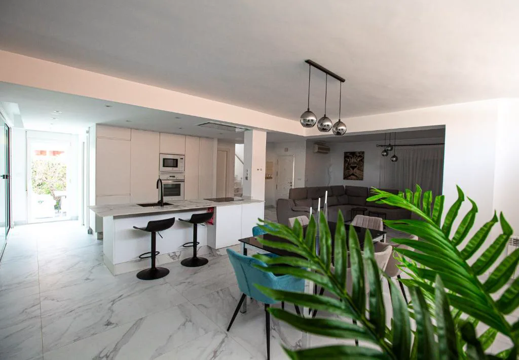 Salón abierto con barra y cocina moderna