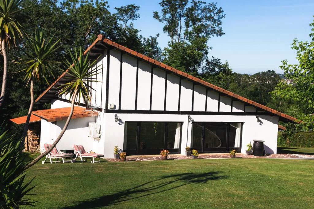 Villa blanca con césped y ventanales