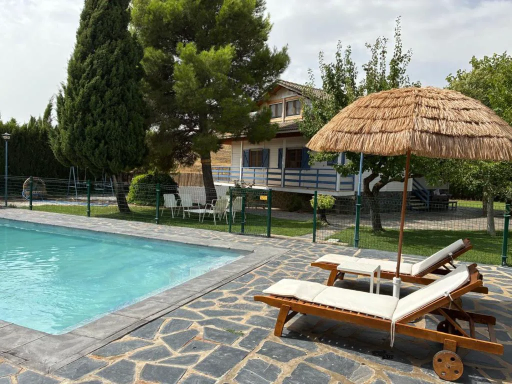 Piscina con tumbonas y sombrilla de paja