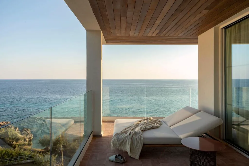 Terraza con tumbona y vistas al mar en calma al atardecer, Villa Le Blanc