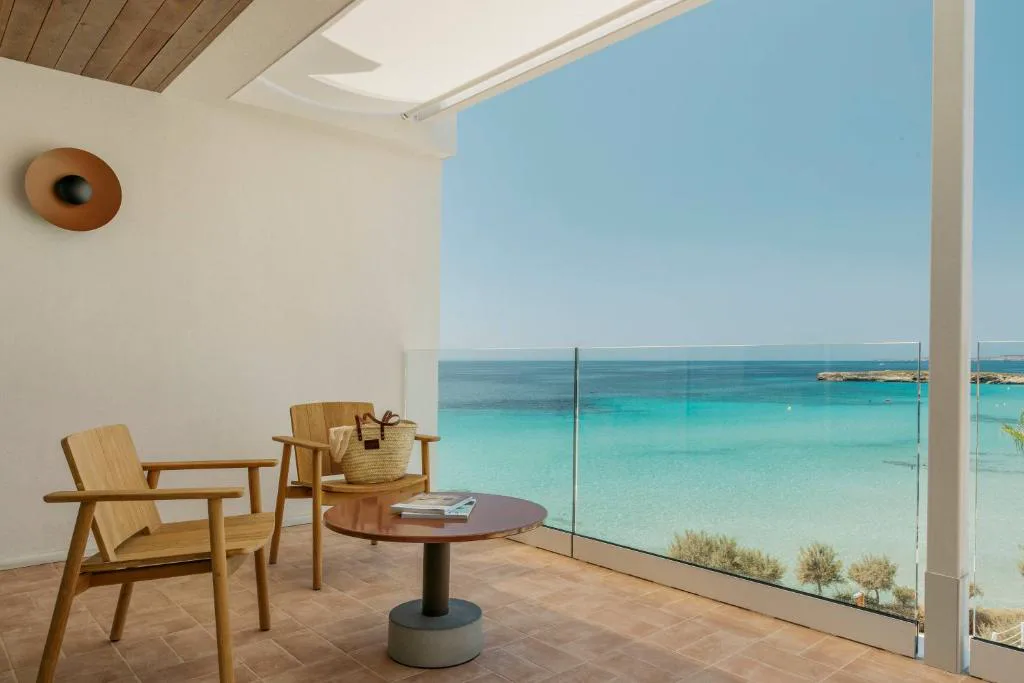 Terraza con sillones de madera frente al mar turquesa de Santo Tomás, Villa Le Blanc