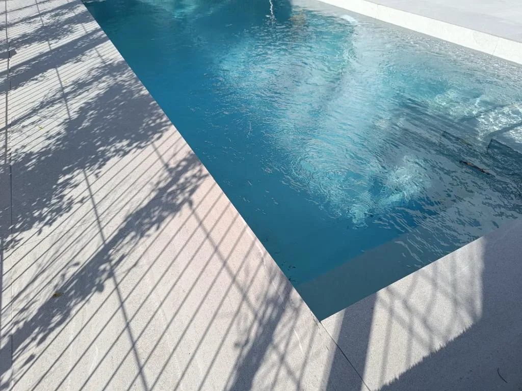 Piscina privada estrecha con suelo de madera y luz cálida