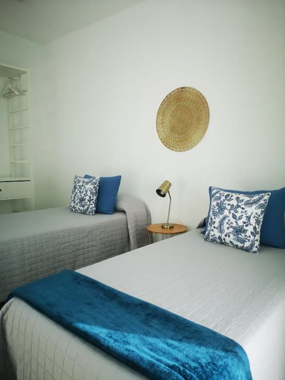 Dormitorio doble con ropa de cama blanca y azul, Villa Montaña Colorada