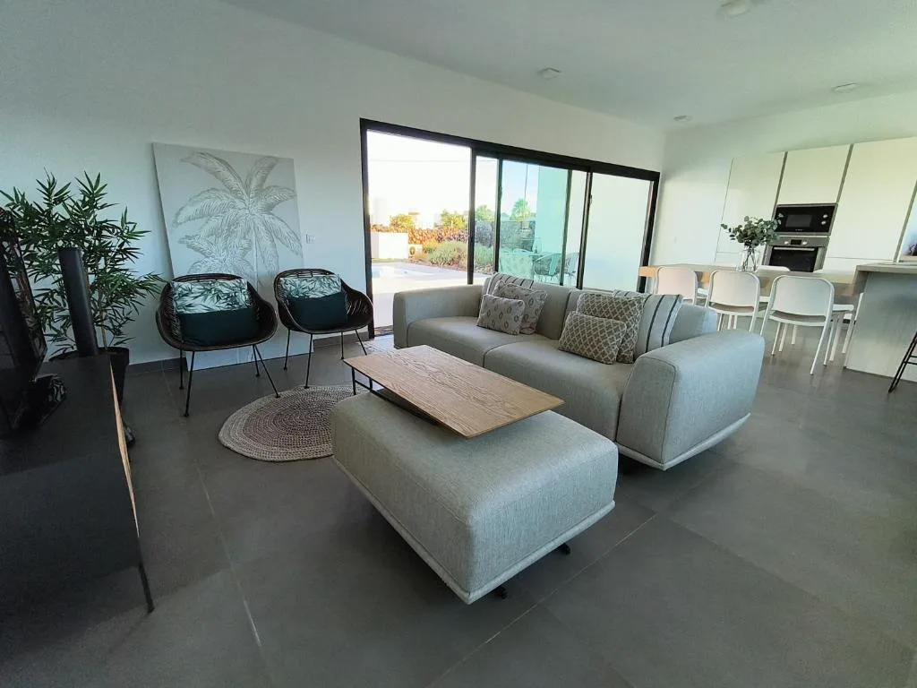 Salón con sofás grises y acceso directo al jardín, Villa Montaña Colorada