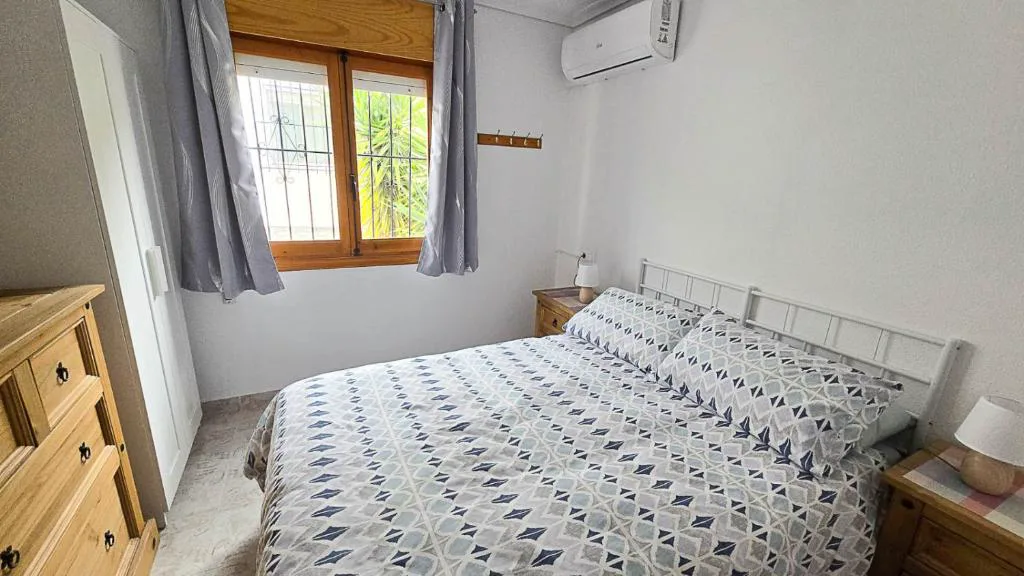 Dormitorio con cama doble y cabecero de madera