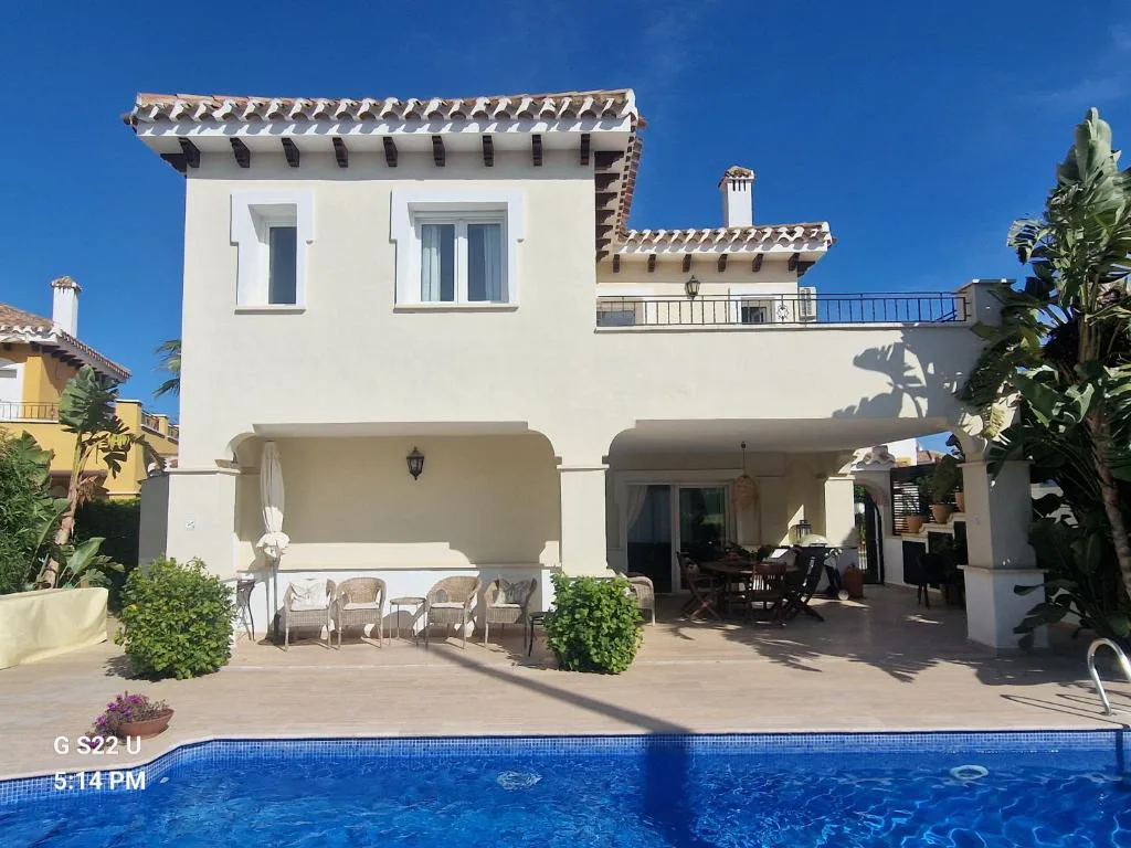 Piscina privada al pie de una villa blanca con jardín