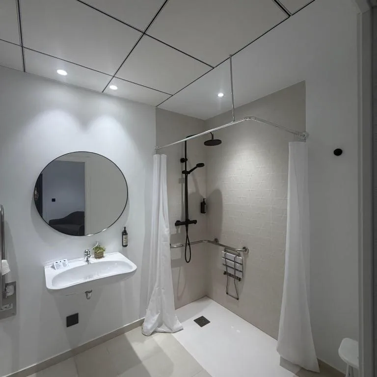 Baño moderno con espejo redondo