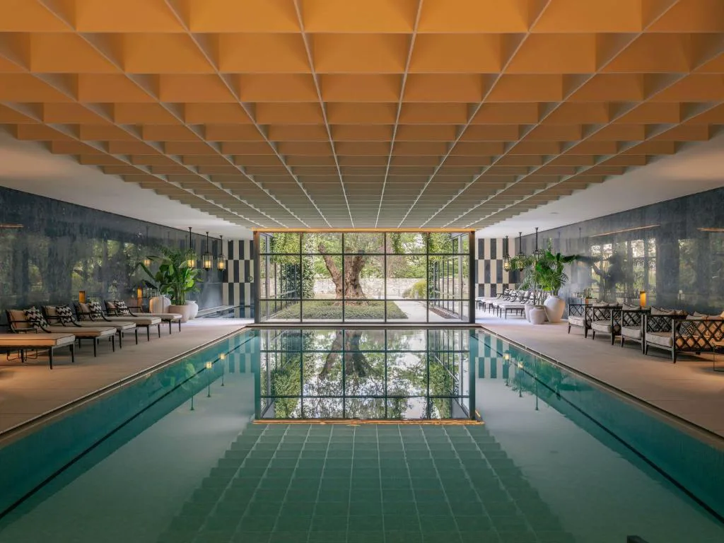 Piscina cubierta de Vinha Boutique Hotel con vistas al jardín a través de un gran ventanal