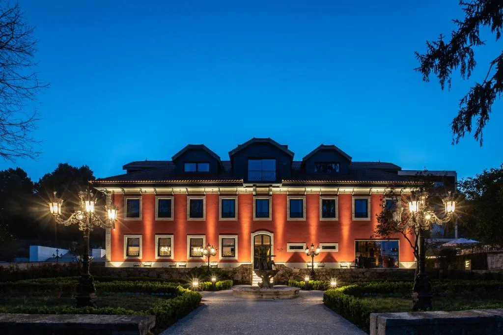 Fachada iluminada al atardecer de Vinha Boutique Hotel, con fuente y jardines, Vila Nova de Gaia