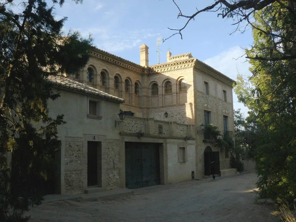 Fachada de piedra de la casa con jardín