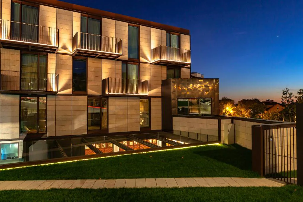 Fachada iluminada al atardecer de Wine & Books Lisboa Hotel, en Ajuda