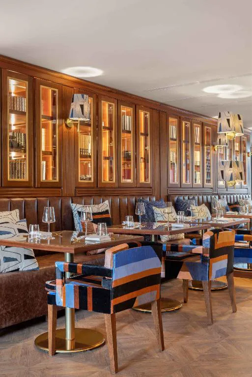 Restaurante de Wine & Books Porto con estanterías acristaladas de libros y botellas de vino